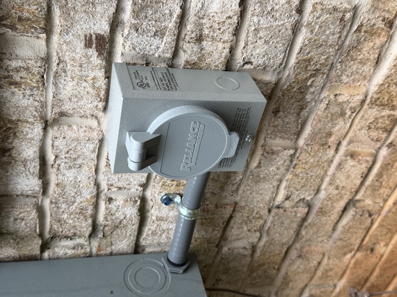 Reliance inlet box mounted on light brick wall with conduit